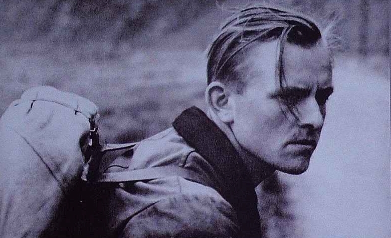 Black and white archival photograph of Willi Graf, member of the White Rose resistance group, wearing a coat and looking to the side with a serious expression.