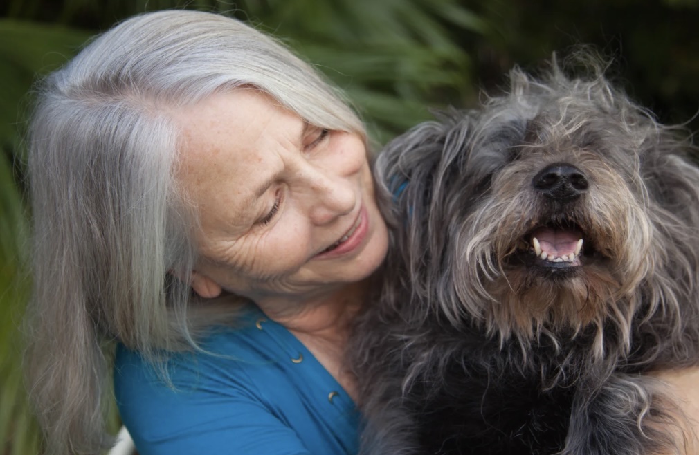 Deborah Lee Prescott holding and smiling down on her beloved Dog Mitzvah.