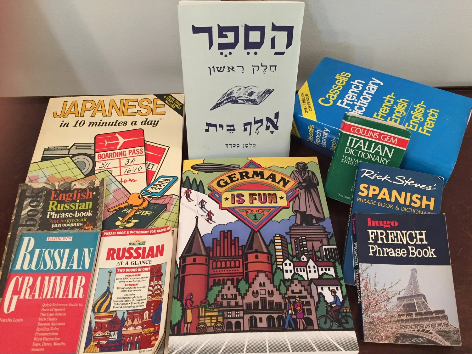 Collection of language learning books and phrasebooks including Japanese, Hebrew, French, Italian, Spanish, Russian, and German