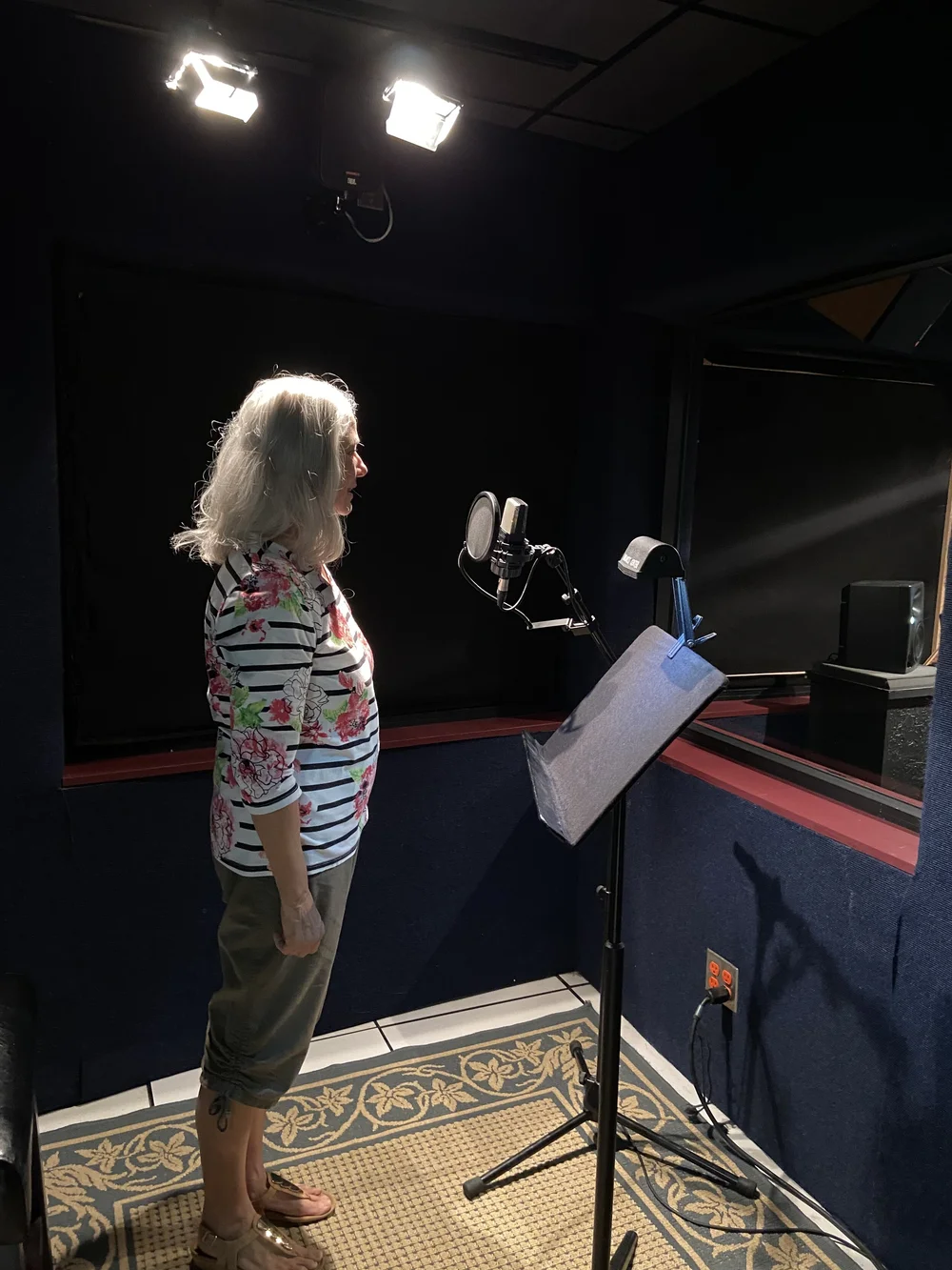 Deborah Lee prescott in a recording studio in front of a microphone reading her books about Mitzvah.